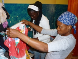 Afrikanische Flüchtlingsfrauen stöbern im gespendeten Fundus der GiM-Kleiderkammer. Foto: humedica/Wolfgang Groß