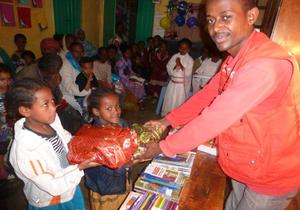 "Endlich geht die Schule wieder los!" Zu diesem freudigen Ereignis und anlässlich des Neujahrfestes überreicht humedica-Mitarbeiter Jacob diesen beiden Mädchen ihre Schuluniform. Foto: humedica/Steven Hofmann