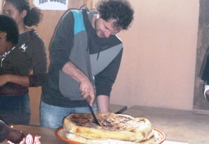 Unser Koordinator Steven Hofmann beim Anschneiden des traditionellen Neujahrskuchen. Foto: humedica