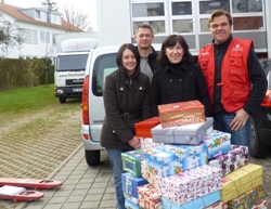 Sonja Danzer, Bernhard Schneider und Brigitte Huss von der Deutschen Bank überreichen 70 Weihnachtsgeschenke an humedica-Mitarbeiter Joachim Panhans (v.l.n.r.). Foto: humedica
