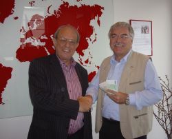 Chorleiter Dr. Dietmar Gräf (links) überreicht den Erlös des Benefizkonzerts an humedica-Geschäftsführer Wolfgang Groß. Foto: humedica/Ruth Bücker