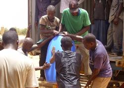 Mit einfallsreichen Methoden zum Abladen der Farbfässer wurde dieses Unterfangen erfolgreich beendet. Foto: humedica/Simone Winneg