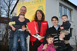 Ulrich Fürst, seine Frau und drei seiner vier Kinder freuen sich über die persönlichen Patenschaftsunterlagen aus den Händen der verantwortlichen Mitarbeiterin Susanne Merkel. Foto: humedica