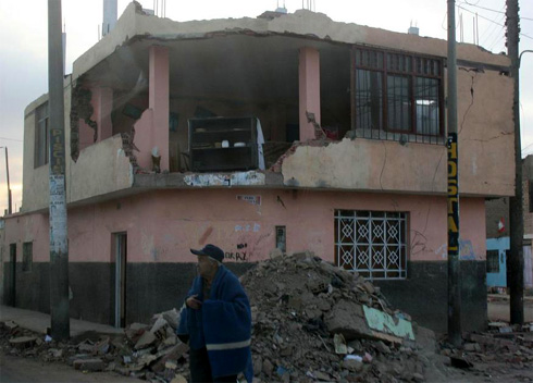 Alter Mann vor zerstörtem Haus in Pisco