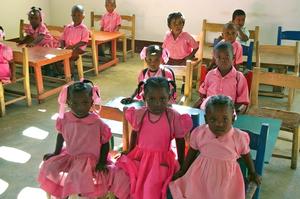 Gespannt sitzen die Kleinen mit ihren rosafarbenen Schuluniformen in ihrer neugebauten Schule in Marbial. Foto: humedica/ Wolfgang Groß