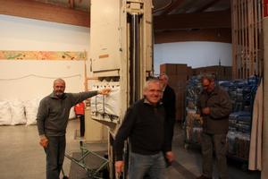 Die 40-jährige Italienerin (Hintergrund) ist die Pressmaschine, die 9.000 Decken sanft in ein handliches Format bringt, um schnell nach Syrien transportiert werden zu können. Foto: humedica/ Klaus Ruhrmann