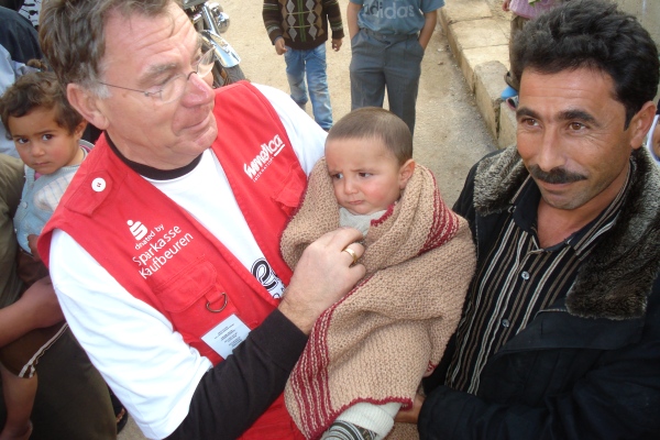 Besonders die selbstgestrickten Babydecken der Frauengruppe aus dem Allgäu bewegten die syrischen Mütter und Väter sehr, die Klaus Ruhrmann (links) und Patrick Khamadi verteilten. Foto: humedica/Patrick Khamadi