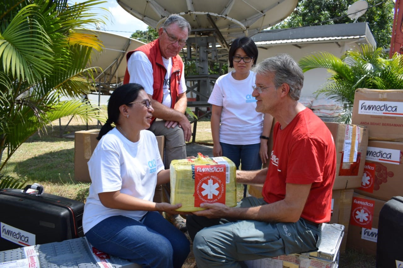Diehumedica-Einsatzkräfte Klaus Ruhrmann (hinten links) und Markus Hohlweck (rechts) bei der Übergabe der Hilfsgüter und des medizinischen Materials mit Yuanita Oktiva (2. von rechts) und Carla Riupassa (links) von der Karya Alpha Omega Foundation. Foto:humedica