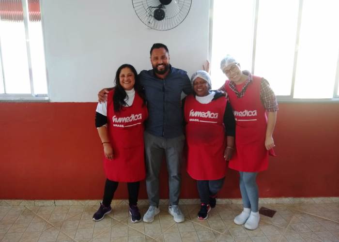 Fußballstar Antonio Da Silva mit dem Küchenteam derhumedica-Kindertagesstätte in Brasilien. Foto: DaSilva