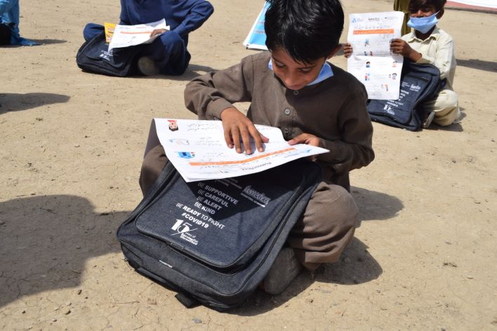 Gespannt schaut dieser Junge in seinen neuen Schulrucksack, der ihm dank der Unterstützung durch humedica auch während der Pandemie ermöglicht, in der Schule dabei zu bleiben. Foto: PMS
